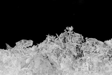 Shiny crystals of ice on black background.