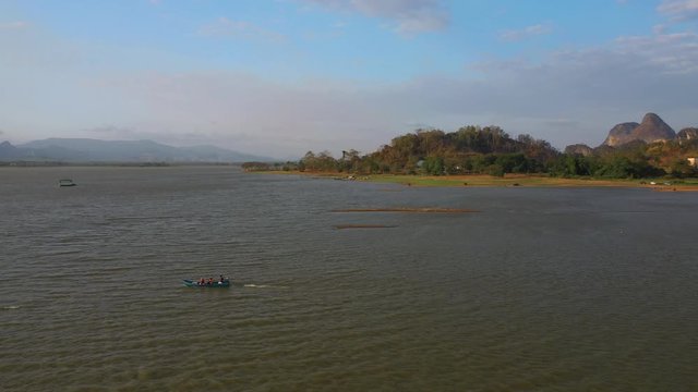 February 29th, 2020 - Perlis, Malaysia : 4k Establishing Aerial View of A Boat Cruising in Timah Tasoh Lake side During Beautiful Sunset. Mountain view in Background. Drone Tracking Right
