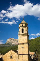 Fototapeta na wymiar Old church tower with views of Parque National de Ordesa near Ainsa, Huesca, Spain in Pyrenees Mountains