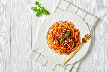 penne bolognese on a white plate, flat lay