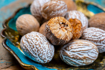Dried nutmegs nuts in vintage bowl
