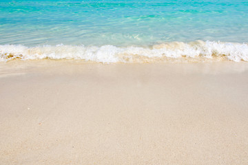 Fototapeta na wymiar Beautiful white sandy beach with The blue sea soft wave