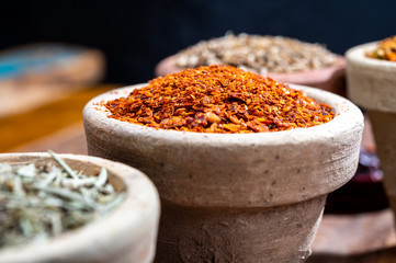 Indian spices collection, dried colorful condiment, nuts, pods and seeds and another spices in clay bowls