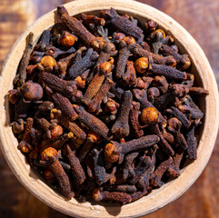 Indian spices collection, dried aromatic cloves flower buds and another spices in clay bowls