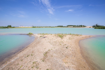 Fototapeta na wymiar Sand quarry oopen pit with blue water