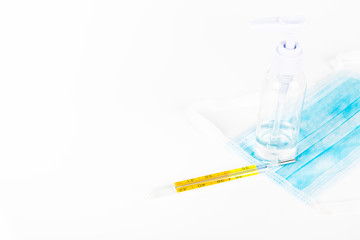 Surgey mask with alcohol gel on withe background