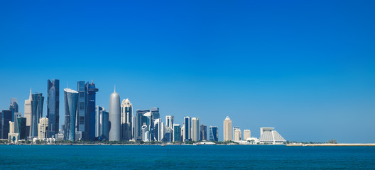 Morning panoramic cityscape view of Doha skyscrapers and towers from Persian Gulf. Futuristic skyline of financial commercial district in Qatar on horizon