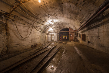 Underground gold mine shaft tunnel drift with rails and light