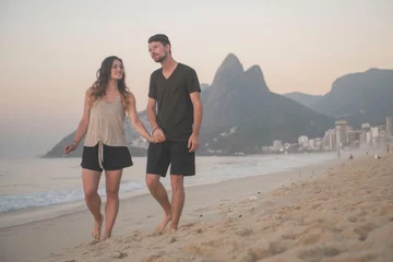 Fotobehang happy travel couple walking along beach in rio de janeiro brazil © Zach