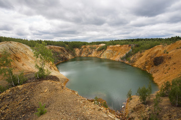 Fototapeta na wymiar Flooded copper pyrite open pit quarry with green water lake