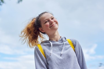 Portrait of teenage girl 15 years old, smiling pretty girl in gray sweatshirt