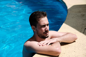 a man sunbathing in the border of the swimming pool