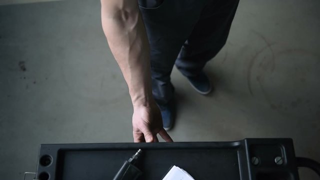 Top view auto mechanic open the box with different tools for car repair at modern service station.