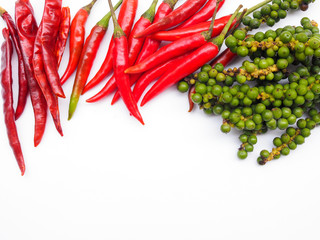 Top view of herbs and spices with top frame of red hot chilli pepper and dried chili and fresh green peppers isolated on white background with copy space.