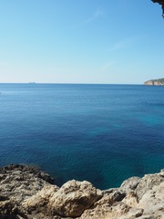 Fototapeta na wymiar vista del mar de una playa de Mallorca con aguas cristailnas y mar en calma. Concepto de vacaciones verano y relax