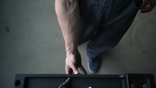 Top view auto mechanic open the box with different tools for car repair at modern service station.