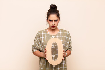 young pretty woman angry, anger, disagreement, holding a number 0.