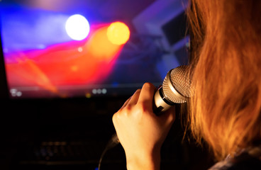Girl is singing karaoke at home. Quarantine time. Self isolation entertainment.  Woman holding...