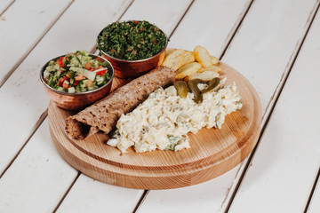 Cooking kebab meat with skewers on grill. Real process. Variety of meat. Chicken, lamb, beef. Mixed grill. Shawarma. Ramadan Kareem, iftar. Family dinner