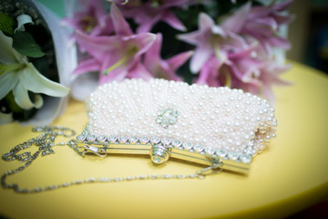 White wedding clutch of the bride with rhinestones and metal inserts.