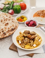 Authentic IRAQI cuisine. Traditional dishes for arabic family dinner. Fried meat kebab with pickles and hummus and bread.  Mix grill saj.