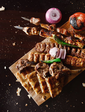 Authentic IRAQI cuisine. Traditional dishes for arabic family dinner. Fried meat kebab with pickles and hummus and bread.  Mix grill saj.