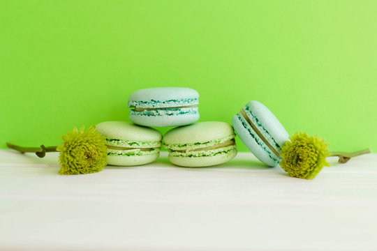 Bright picture of colorful different macaroons with flowers nearby