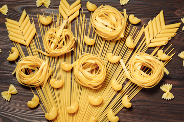 Italian food  and coocking concept.  Menu design.  Various uncooked pasta on wooden background. ...