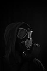 The girl is wearing a military gas mask. Isolated on a black background. Respiratory protection...