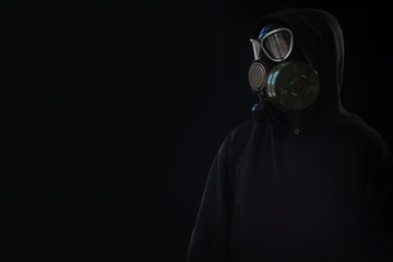 The girl is wearing a military gas mask. Isolated on a black background. Respiratory protection...