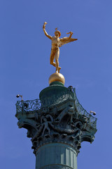 Fototapeta na wymiar Statue of 'Genie de la Bastille' (Bastille genius), a golden bronze by French Jacques Edme Dumont, on the top of the July Column statue at the Bastille square, Paris France - shot August 2015