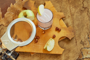 Yogurt with apple and nuts on a wooden background. Daylight.
