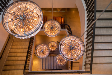 6 Chandeliers hanging in a spiral staircase atrium