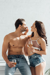 Couple with glasses of wine smiling, looking at each other and girl touching male nose