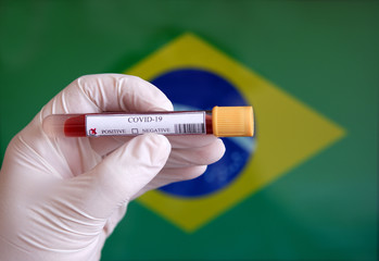 COVID-19 Pandemic Coronavirus concept ; Close-up of a Positive COVID-19 blood test sample tube with Flag of Brazil at background. Blood testing for diagnosis new Corona virus infection.	
