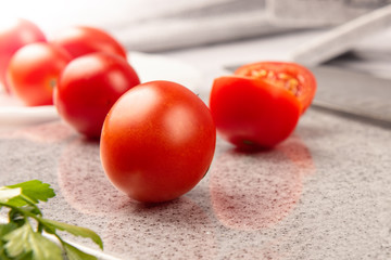 Fresh tomatoes on a cutting kitchen board made of artificial stone