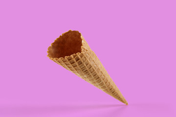 Empty, crunchy wafer cone for ice cream against pink background. Concept of food, treats. Mockup,...