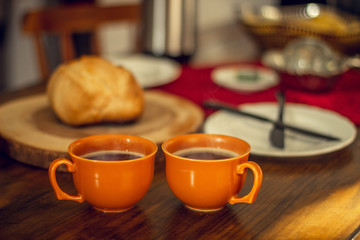 Breakfast table wood with coffee cups and hot bread.