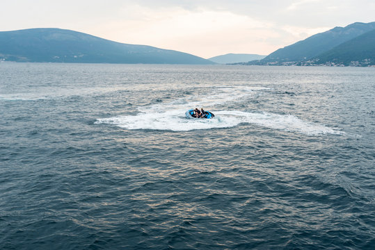 a guy and a girl riding a  hydrocycle in the sea near the shore. Montenegro, Boka - 22/07/2019