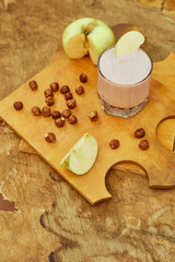 Yogurt with apple and nuts on a wooden background. Daylight.