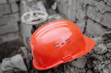  Rusty valve on the pipeline. Safety orange helmet and valve on the heating main. Outdated clinker...