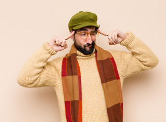 young cool bearded man looking concentrated and thinking hard on an idea, imagining a solution to a...