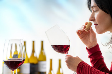 Female sommelier smelling wine cork at tasting.