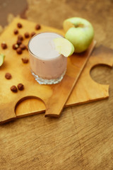 Yogurt with apple and nuts on a wooden background. Daylight.