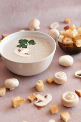 creamy mushroom cream soup with champignons serving in delicate pink colors