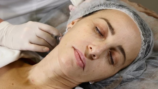 Cosmetician in gloves making neck skin lifting injection. female client gets facial beauty procedure in healthcare clinic. Anti-wrinkle collagen and hyaluronic acid injections. Full hd