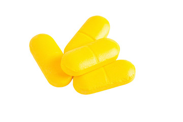 Closeup of yellow pills isolated on white background.