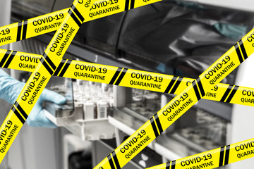 Coronavirus yellow warning tapes against hand of scientist in blue disposable glove showing test...