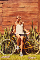 Fototapeta na wymiar Pretty woman standing with old bicycle outdoors.