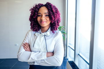 successful charming african american woman with purple curls hair in white shirt and black pencil...